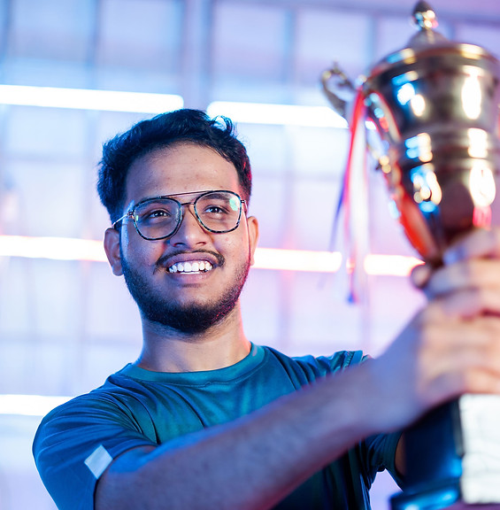 A smiling person raising a trophy