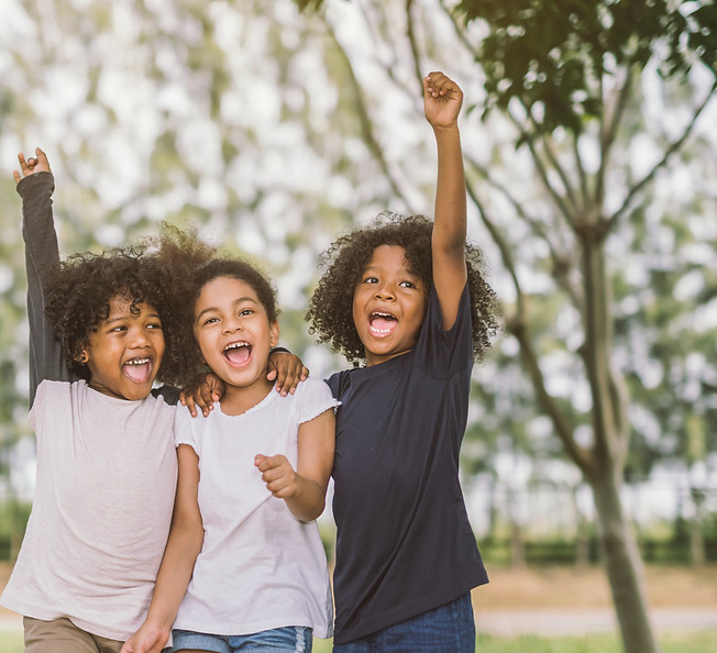 Three children cheering outdoors